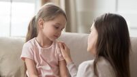 Loving mom talking to upset little child girl giving support