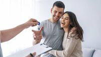 Happy couple is taking keys from their new house from broker and smiling.