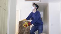 Man Climbing Into Loft To  Insulate House Roof