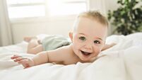 cute baby boy lying on a white bed