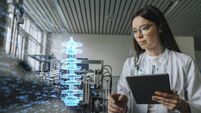 Female engineer with digital tablet examining development of industrial product
