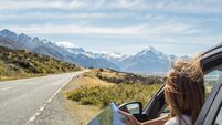 Portrait of young woman in car looking at map