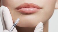 Close up of woman receiving botox injection in lips