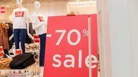 Sale up to 70 percent red sign. Red display with sale up to seventy percent inscription sticked on the store window.Seasonal dis