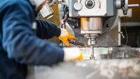 A worker in a factory working on a traditional milling machine