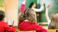 Children Raising Hands In Class, Rear View