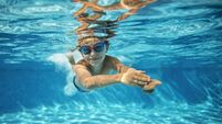Little boy swimming underwater in pool