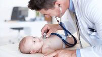 Baby girl looking at her caring doctor curiously