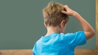 Thinking pupil scratching his head in classroom