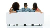Rear view of friends sitting on couch