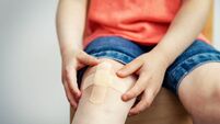 child knee with adhesive medical plaster strip bandage