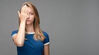Young female covers face, feels fatigue, needs good rest. Human emotions, facial expression concept. Copy space