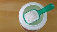 Top view of green laundry spoon full of laundry soaker powder to pre soak cloths
