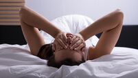 Close-up Of A Stressed Young Woman Lying On Bed