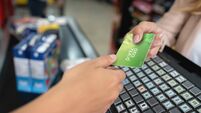 Close-up holding a rewards card at the supermarket