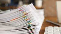 Lot of documents fastened with multicolored paper clips lying on table closeup